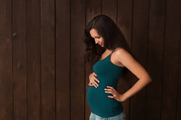 Zwangere Vrouw Jeans Shorts Groene Top Houdt Handen Buik Een — Stockfoto