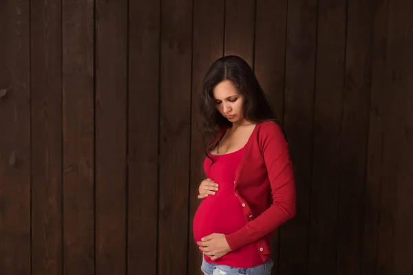 Kerst Zwangere Vrouw Jeans Shorts Rode Top Houdt Handen Buik — Stockfoto