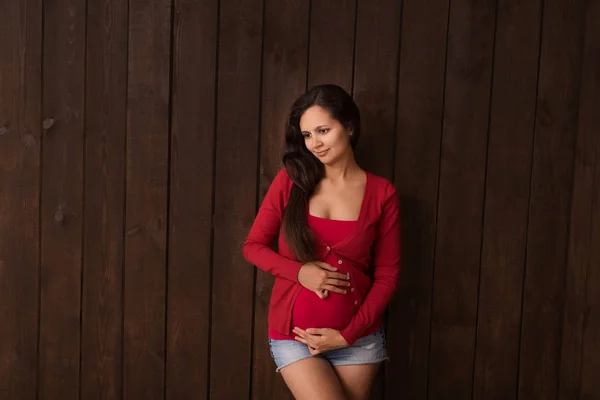 Mulher Grávida Natal Calções Ganga Top Vermelho Mantém Mãos Barriga — Fotografia de Stock