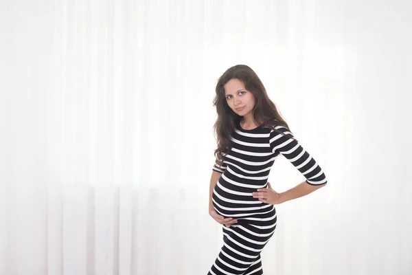 Mulher Grávida Vestido Listrado Mantém Mãos Barriga Fundo Branco Gravidez — Fotografia de Stock