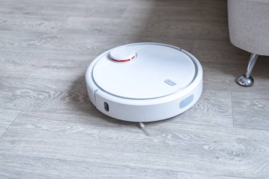 Robotik süpürge odayı temizliyor. Akıllı temizlik teknolojisi.