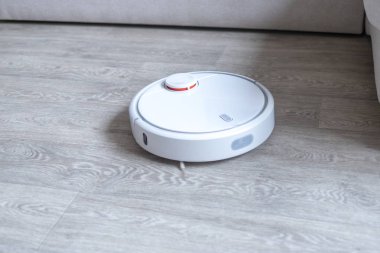 Robotik süpürge odayı temizliyor. Akıllı temizlik teknolojisi.