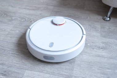 Robotik süpürge odayı temizliyor. Akıllı temizlik teknolojisi.
