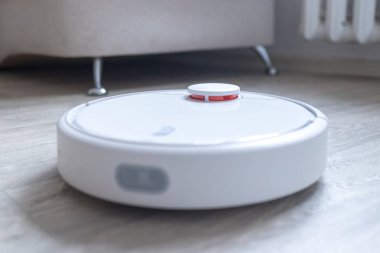 Robotik süpürge odayı temizliyor. Akıllı temizlik teknolojisi.