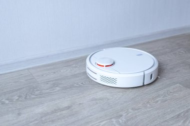 Robotik süpürge odayı temizliyor. Akıllı temizlik teknolojisi.