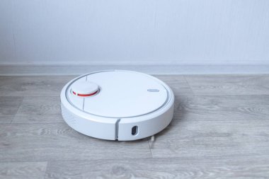 Robotik süpürge odayı temizliyor. Akıllı temizlik teknolojisi.