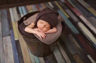 Şapkalı şirin yeni doğmuş bebek. Karanlık bir arka planda uyuyan bebek. Yeni doğan bebeğin yakın plan portresi. Bebek eşyaları paketleme şablonu. Çocuk odası. Tıbbi ve sağlıklı konsept.