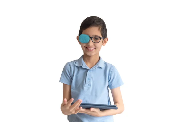 戴眼镜男孩的画像 眼镜补丁 带着平板电脑的男孩治疗懒眼 远程学习 远距离教育 Covid Coronavirus 干家务活 — 图库照片