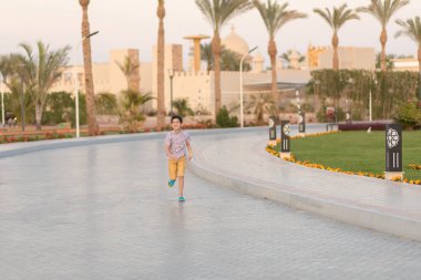 Gömlekli çocuk koşuyor.