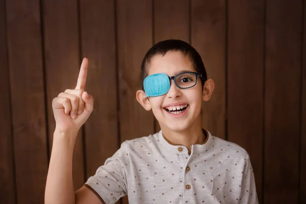 Portrait of boy in glasses with patch. Eye patch for glasses t treat lazy eye, amblyopia, strabismus.