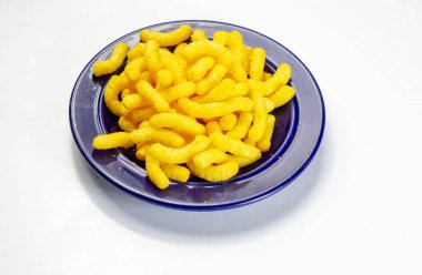 Beyaz arka planda, saman sepetinde mısır çubukları.