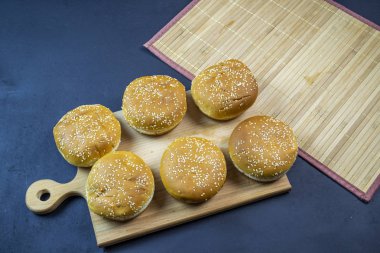 Koyu bir arka planda tahta tepside hamburger.