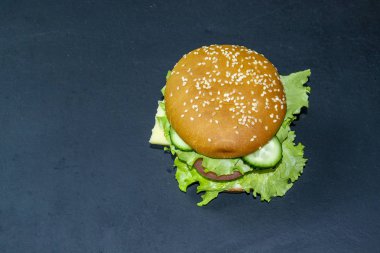 Koyu bir arka planda tahta tepside hamburger.