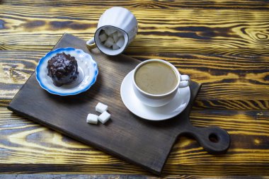 Sütlü kahve, ahşap arka planda kurabiyeler, üst manzara.