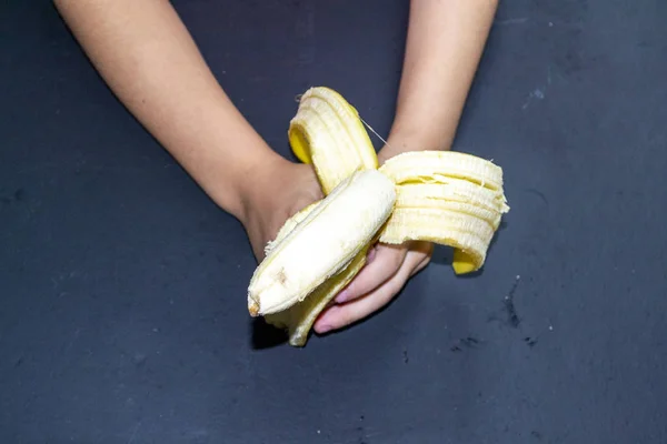 Niña Sostiene Plátano Sobre Mesa Una Rama Plátanos Sobre Mesa — Foto de Stock