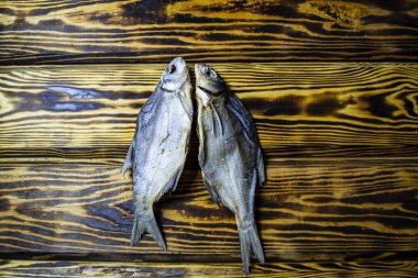 Ahşap arka planda tuzlanmış kuru balık, üst manzara.