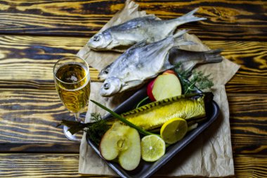 Ahşap arka planda meyve ve şaraplı füme uskumru balığı.