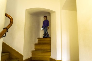 Pencerenin kenarında oturan küçük kız, çok odaklı.