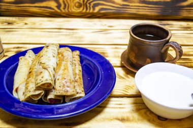 Tereyağlı ve ekşi kremalı gözleme, Maslenitsa büyük bir yığın kızarmış krep, çay, seçici odaklanma, üst görünüm