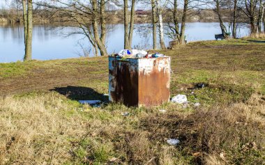 Doğadaki çöp, 15 Şubat 2020 'de Minsk, Belarus' taki bir parkta ev atığı için metal bir kutu.
