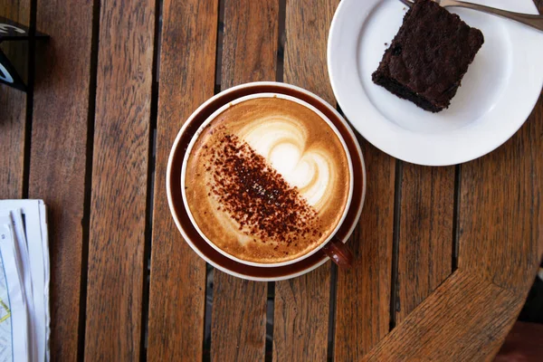 Masa, bir fincan kahveli ve kekli kahve.