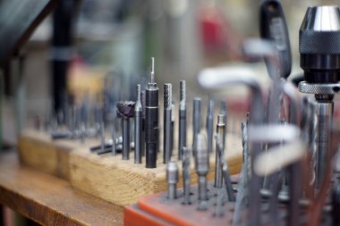 Tatbikatlar mekanik atölyesindeki bir masanın üzerine düzensiz vidalar