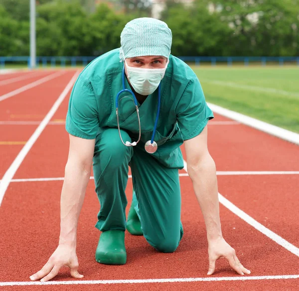 Stadyumdaki erkek doktor başlangıç pozisyonunda - bir kariyer ve sağlık yarışı - tıbbi bakımda rekabet 