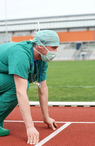 Stadyumdaki erkek doktor başlangıç pozisyonunda - bir kariyer ve sağlık yarışı - tıbbi bakımda rekabet 