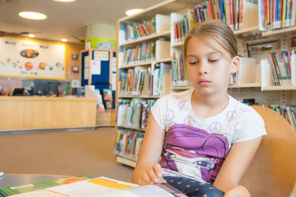 Chica en una biblioteca — Foto de Stock
