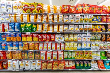 Farklı doğadan ürünlerle rafa kaldırılmış, İtalya 'da bir süpermarketin içindeki raflarda çeşitli yiyecekler sergileniyor. Atıştırmalıklar.