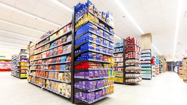 Roma, İtalya. 2005 Aralık 2018: İtalya 'da bir MA süpermarketinin raflarında farklı nitelikte ürünler sergileniyor. Atıştırmalık ve kahvaltı paketleri.