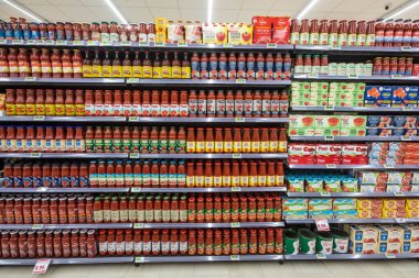 İtalya 'da bir MA süpermarketinin içinde eşya ürünleri olan raflar. Domates reçeli çeşitleri. Raflar dolu ve düzenli..