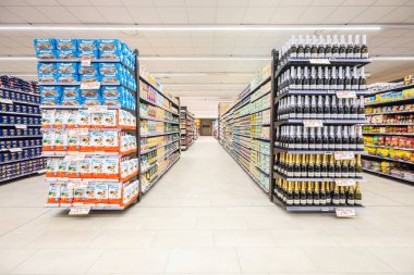 İtalya 'da bir MA süpermarketinin içinde eşya ürünleri olan raflar. Çeşitli atıştırmalıklar, bir şişe şarap, pirinç ve konserve yiyecekler. Raflar dolu ve düzenli..