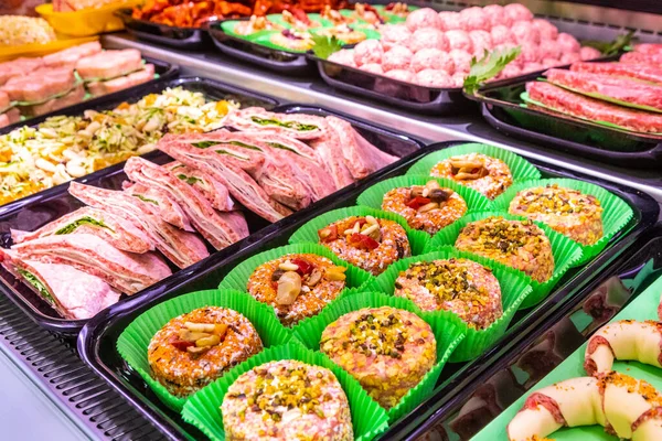 Butcher, meat department. Several products displayed in a showcase. Italian food in tray with different preparation and meat ingredients.