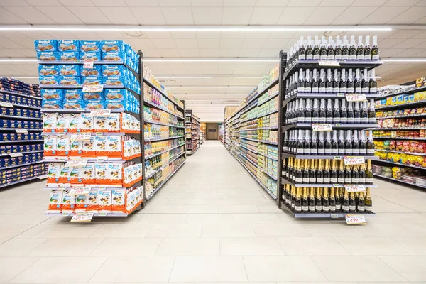 İtalya 'da bir MA süpermarketinin içinde eşya ürünleri olan raflar. Çeşitli atıştırmalıklar, bir şişe şarap, pirinç ve konserve yiyecekler. Raflar dolu ve düzenli..