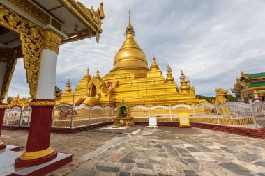 Mandalay / Myanmar - 24 Temmuz 2019: Kuthodaw Pagoda, Mandalay bölgesindeki altın sarısı Budist dini yapı. Bulutlu gökyüzü.