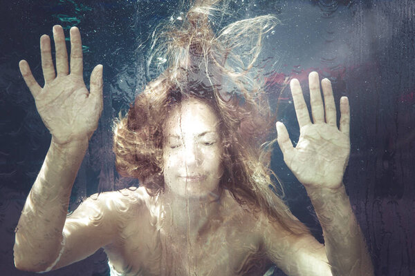 Woman under water. A young woman is trapped in a water surface. Hands resting on. summer feeling. Underwater.