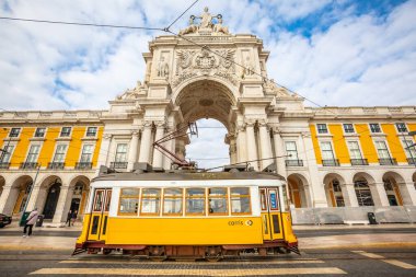 Lizbon, Portekiz. 4 Ocak 2019: Rua Augusta Zafer Kemeri Portekiz 'in Lizbon şehrinin tarihi merkezinde. Sokakta yürüyen insanlar. Bulutlu mavi gökyüzü. Şehir taşımacılığı için tramvay.