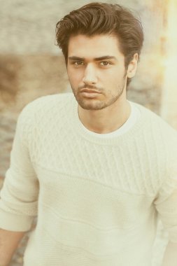 Dışarıdaki yakışıklı genç adam. Moda saç stili. Şık saçlar, çekici ve çekici bir görünüş. Şehirdeki açık havada. Yoğun güneş ışığı, yumuşak ve uyum tarzı sahne.