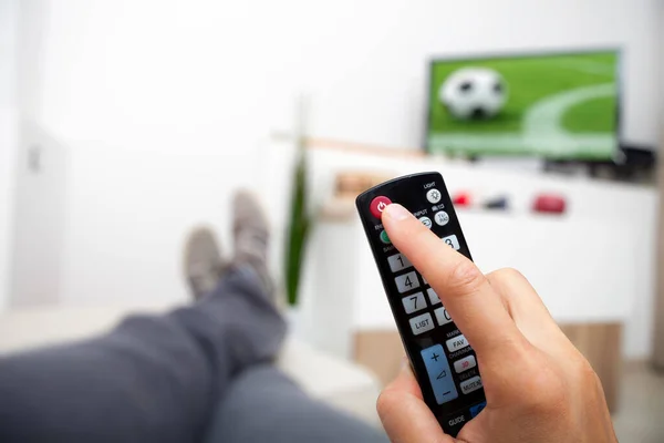 Televizyonu kapatıyorum. Uzaktan kumanda elinde. Adam uzanmış futbol seyrediyor ve televizyonu kapatıyor..
