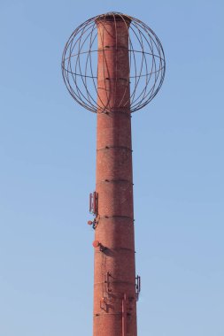 Ferrara, İtalya. 21 Nisan 2018: Tepesinde küresel metal bir yapı olan kule. İtalya 'nın Ferrara kentindeki endüstriyel mimarinin ayrıntıları. Arka planda mavi gökyüzü.