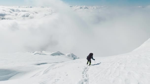 Mountaineer Man está usando el hacha de hielo, descendiendo en la ladera nevada de la montaña — Vídeo de stock