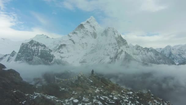 Человек на вершине Нангартсанга смотрит на гору Ама Даблам. Гималаи, Непал. Вид с воздуха — стоковое видео