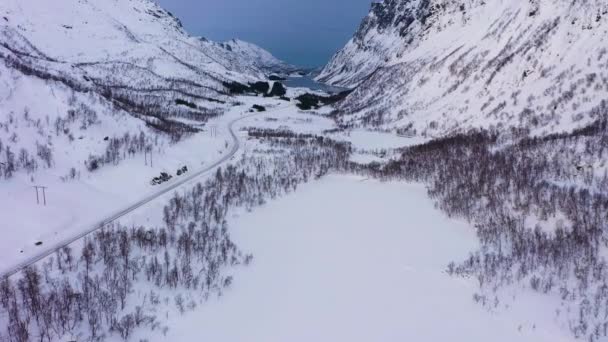 Montañas, carretera y lago congelado en invierno. Valle. Troms, Noruega. Vista aérea — Vídeo de stock