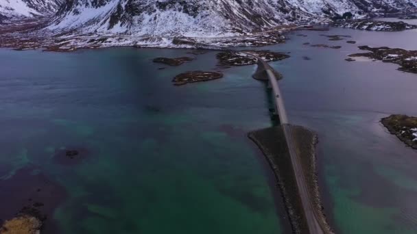 Fredvang Bridge и Volandstind Mountain зимой. Лофотен, Норвегия. Вид с воздуха — стоковое видео