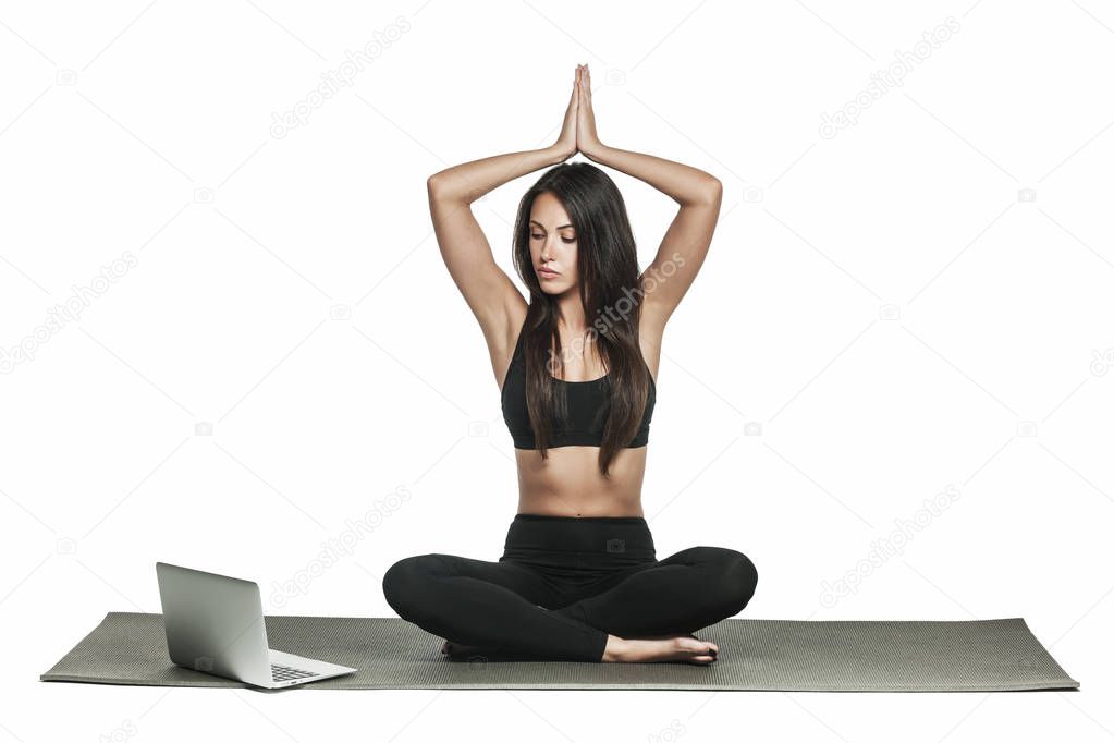 Young woman in sporty outfit glancing at her laptop