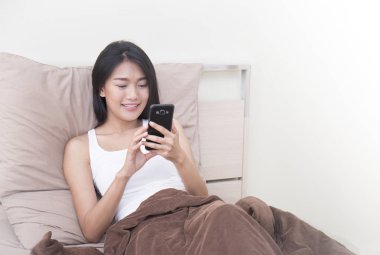 Akıllı telefonla gülümseyen genç kadın manifatura