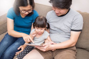 Asya Aile kanepede oturan ve tablet vasıl arıyorsunuz