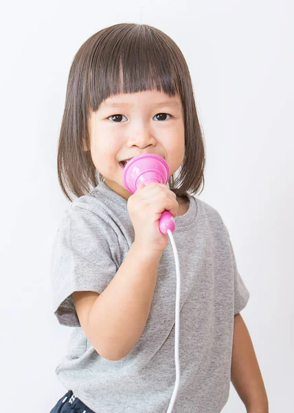 Ázsiai szép kislány, éneklés a mikrofon — Stock Fotó