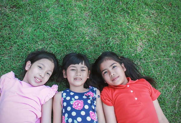 Yeşil Çim Üzerinde Yalan Parkta Ararken Çocuk — Stok fotoğraf